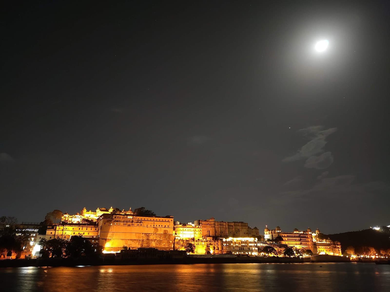 City Palace lit up at night, seen from Ambrai Ghat, Udaipur