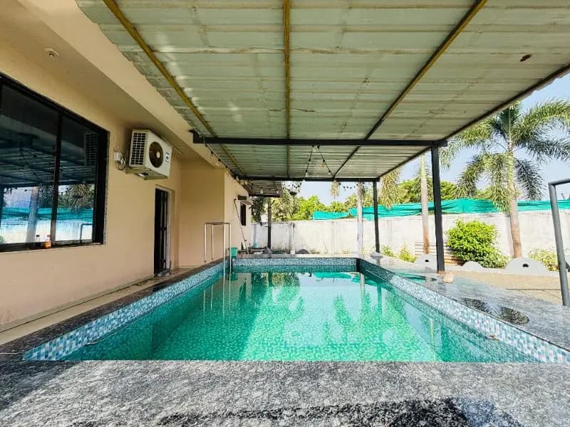 Covered swimming pool at HappyPlay farmhouse in Olpad, Surat