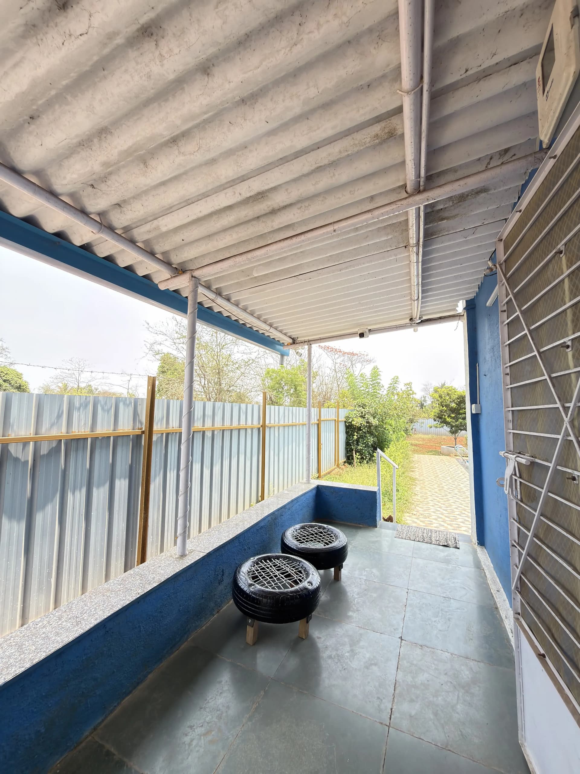 Covered outdoor area beside a pool at a farmhouse in Karjat